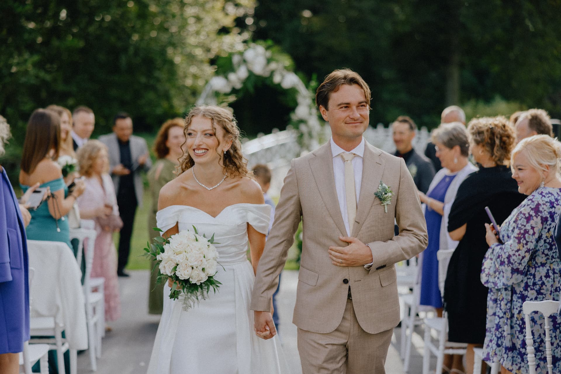 A newly married couple leaving their outdoor garden ceremony together