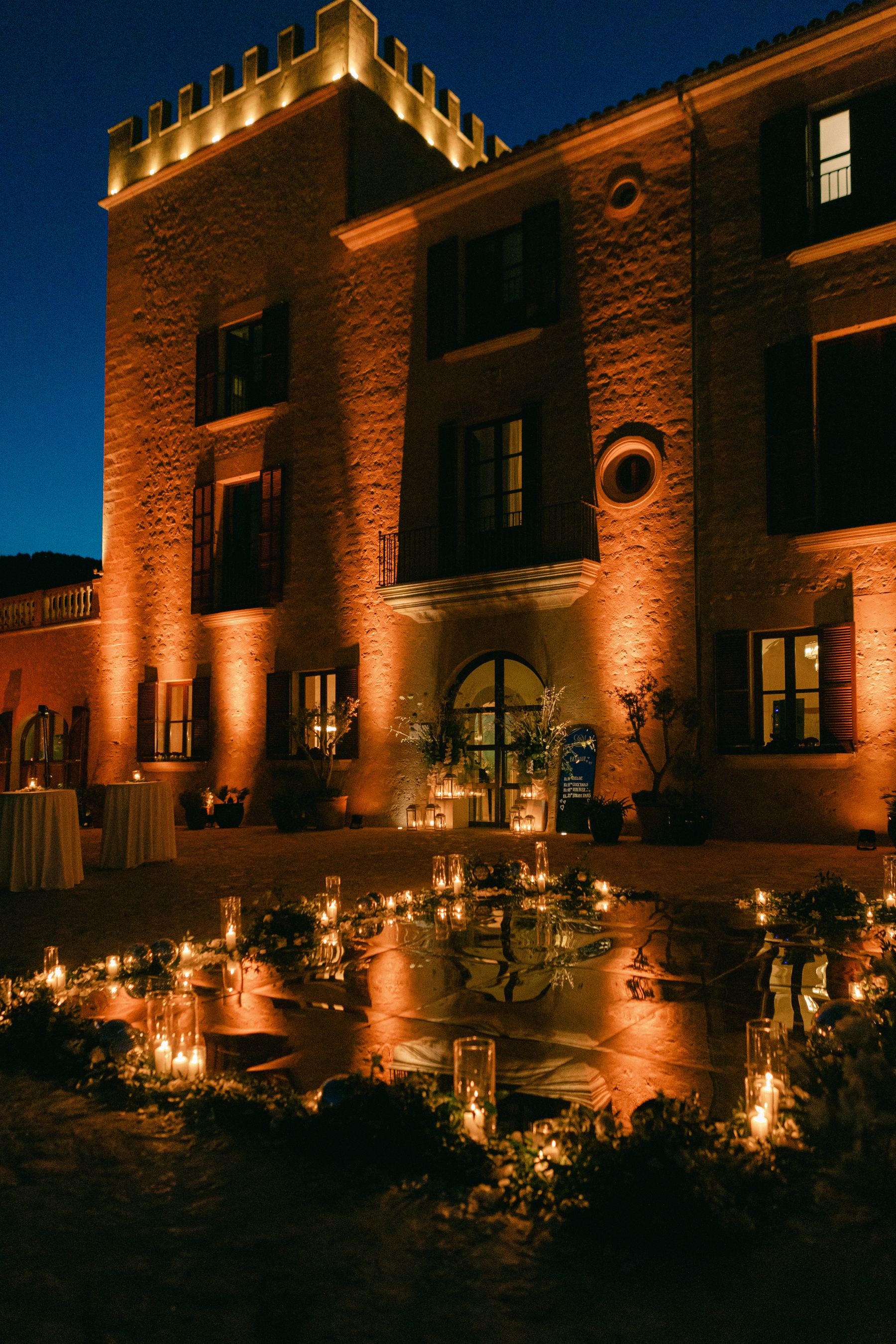 Candlelit evening reception at a historic Mallorcan estate with warm golden lighting