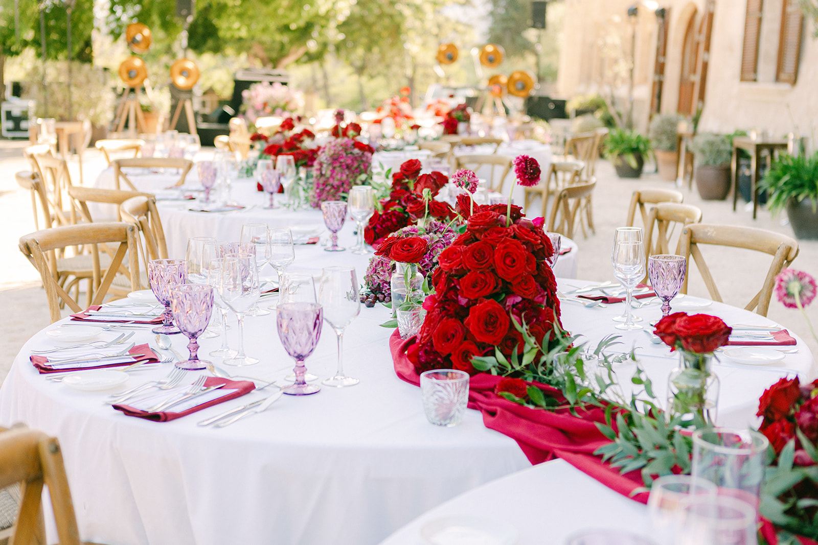 Crimson roses and amethyst glass — a table that commands attention
