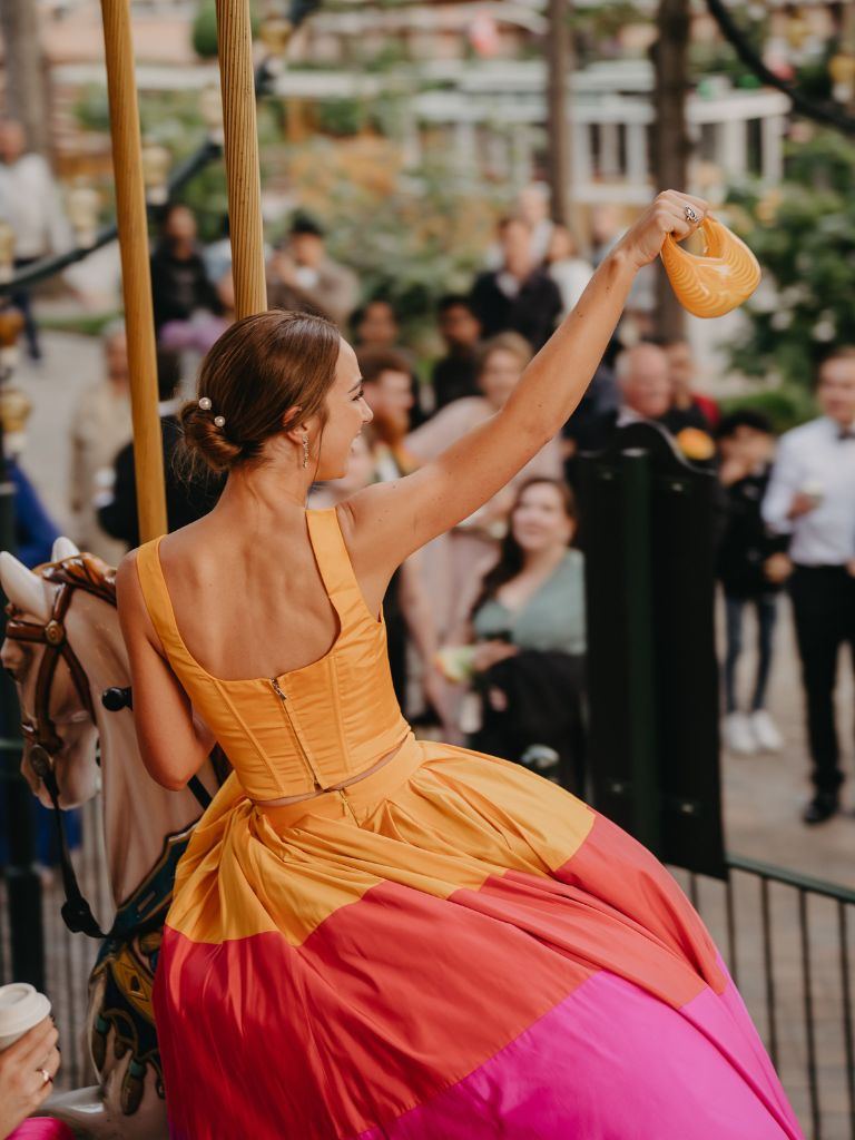 Tivoli carousel, orange and magenta, a cup raised